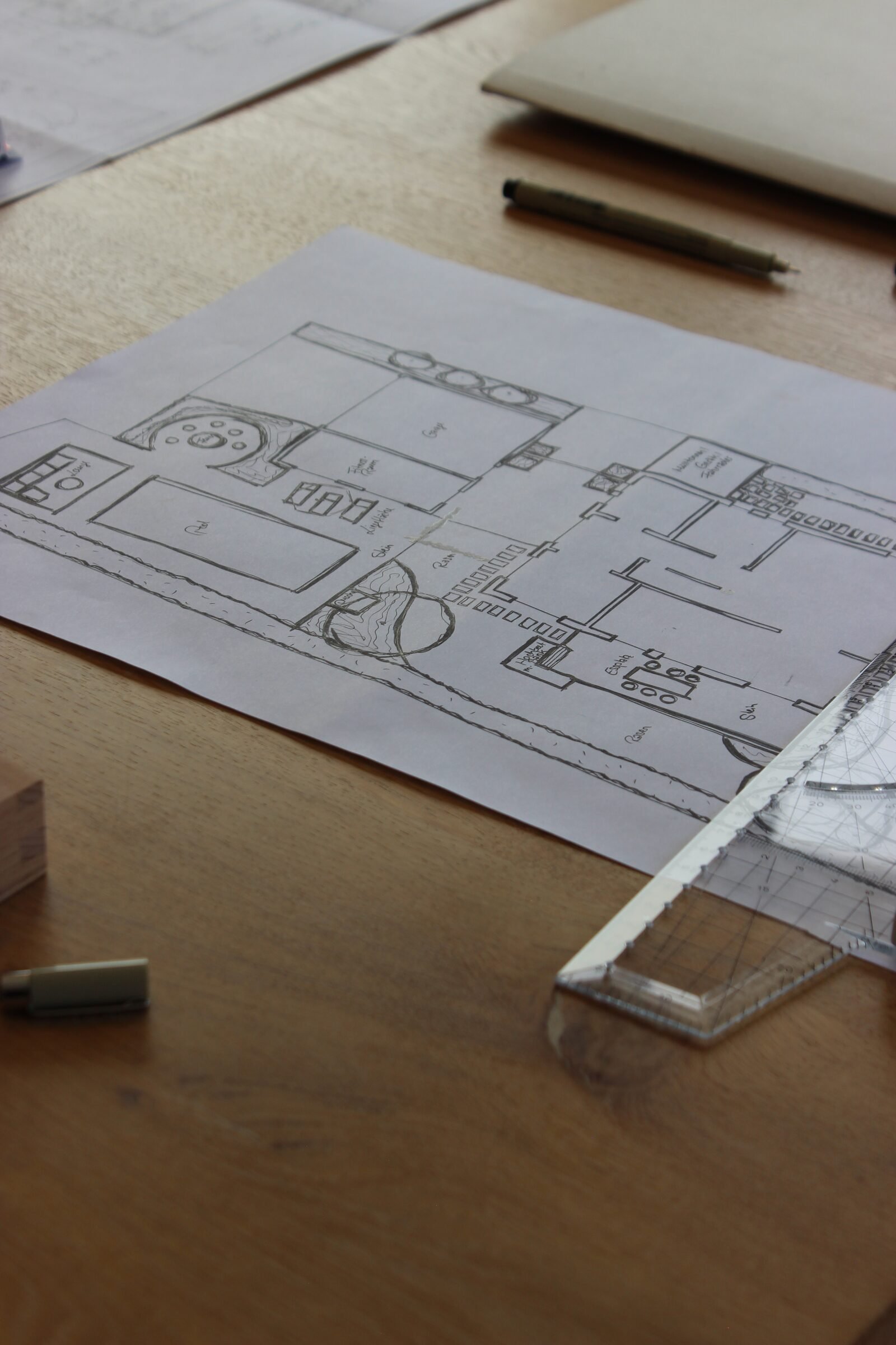 Grundrissskizze auf dem Schreibtisch neben Stift und Lineal